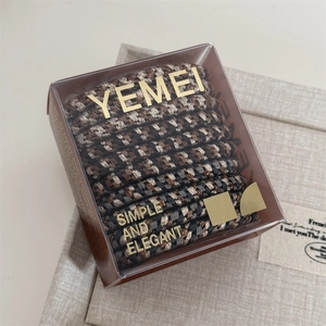 Detail of multi-color houndstooth elastic hair ties set in premium transparent box packaging