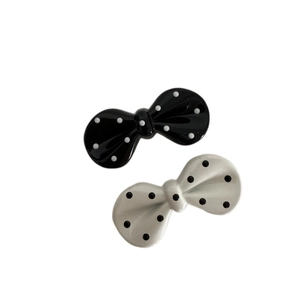 Polka dot bow hair clips set with black and white patterns on plain white background