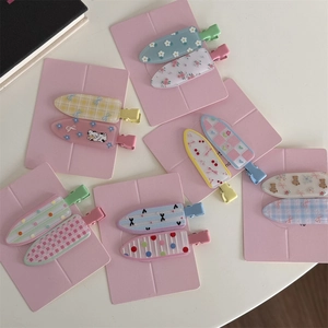 Detail showing a variety of floral, plaid, and polka dot patterns on cute metal hair clips