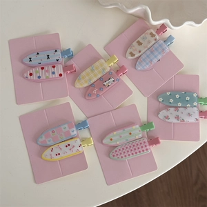 Set of 10 cute floral and checkered hair clips for women on a pink display card
