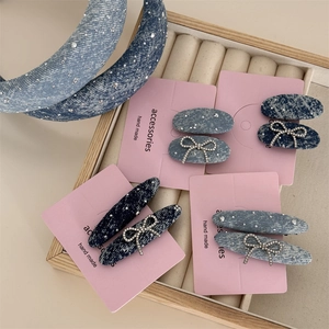 Makroaufnahme von Denim-Haarreifen und Clips mit glitzernden Strasssteinen und Schleifen