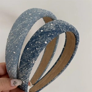 Handgehaltene Aufnahmen von verwaschenen Denim-Stirnbändern in Hell- und Dunkelblau mit Strass