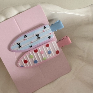Detailed macro view of two cute floral and polka dot hair clips on a display card