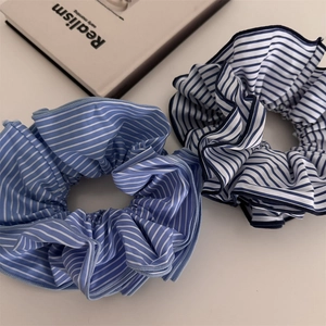 Vue détaillée de chouchous en tissu à rayures bleues sur fond de livre minimaliste