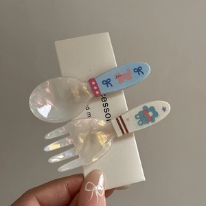 Detailed macro of creative spoon and fork shaped hair clips with colorful iridescent resin finish