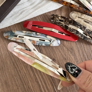 Detailansicht der Metallfeder und Acetat-Texturen dieser eleganten Haarspangen für Damen