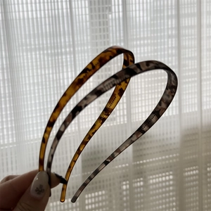 Détail de serre-têtes fins en écaille de tortue aux motifs ambre et léopard