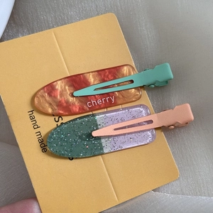Detail of sweet floral hair clips including amber cherry pattern and glittery sequins finish
