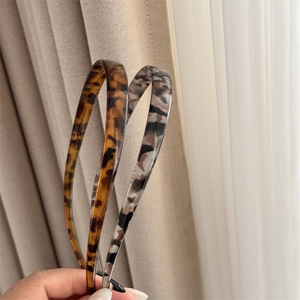 Détail de deux serre-têtes fins avec motifs écaille de tortue et gris à fini brillant
