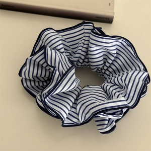 Vue détaillée du chouchou à rayures bleues et blanches avec bordure bleu foncé