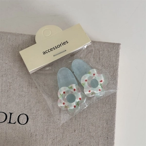 Détail de deux barrettes à fleurs bleues au style coréen mignon avec motif à carreaux