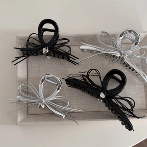 Lot de quatre pinces à cheveux chic noires et argentées avec noeuds et pendentifs coeur