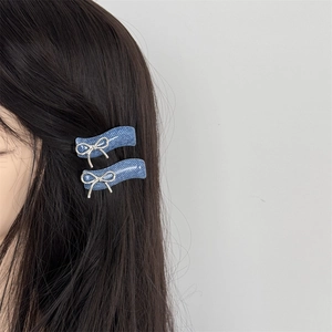 Blue denim texture hair clips with silver metal bows shown on model's hair