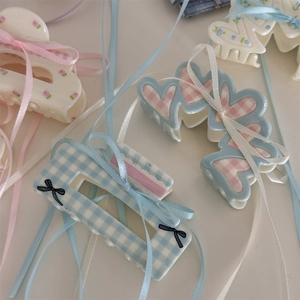 Pinze per capelli a fiori e quadretti stile balletto con nastri eleganti su sfondo morbido