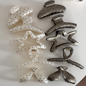 Detailed macro view of assorted French polka dot hair claws in five elegant shapes