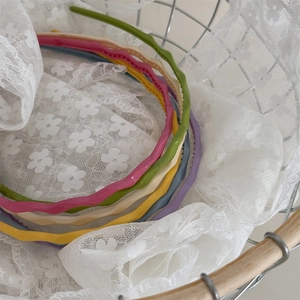 Lot de six serre-têtes ondulés fins en plastique coloré pour filles dans un panier
