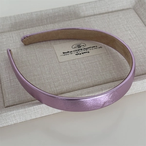 Détail d'un serre-tête violet métallisé avec doublure en daim antidérapant sur lin
