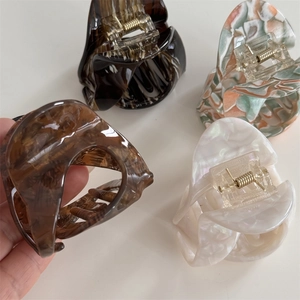 Detail shot of small acetate claw clips in tortoiseshell and marble patterns