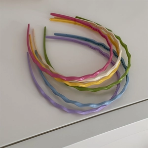 Détail de serre-têtes ondulés colorés en plastique avec dents antidérapantes de style