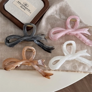 Detail von vier Schmetterlings-Haarklammern mit Marmormuster in Schwarz, Rosa und Weiß