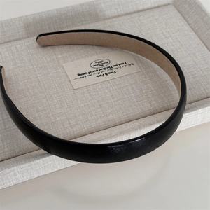 Détail de la texture cuir mat et doublure en velours antidérapant du serre-tête noir