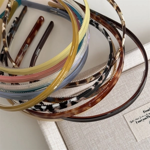 Macro detail of slim acetate headbands with tortoiseshell texture and non-slip teeth