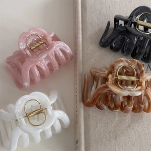 Flat lay of marble texture hair claws in pink, cream, black and coffee colors