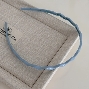 Détail de serre-tête ondulé bleu Morandi avec dents antidérapantes et une finition mate chic