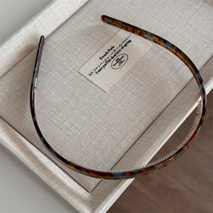 Detail of tortoiseshell acetate headband showing inner grip teeth and polished finish