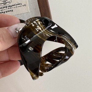 Macro shot of acetic acid hair claw clip with classic tortoiseshell texture and polished finish