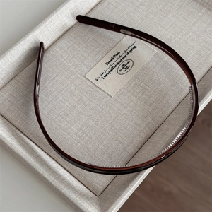 Detail view of thin dark brown tortoiseshell acetate headband with anti-slip inner teeth