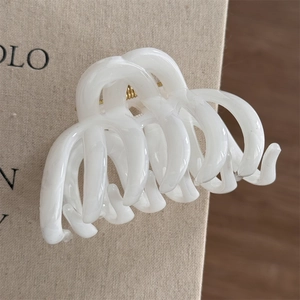 Detailed macro view of the interlocking cream resin claw clip showing the metallic spring