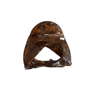 Polished tortoiseshell acetate hair claw clip with interlocking rings design on white background