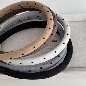 Close-up of retro sponge headbands with polka dot patterns in five neutral colors
