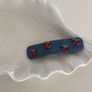 Nahaufnahme der Jeans-Haarklammer mit roten Strass-Kirschen und grünen Blattdetails