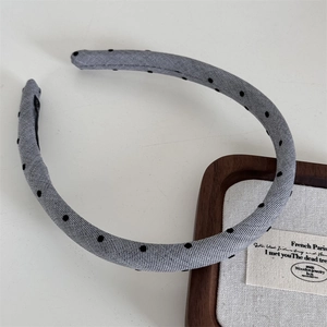 Close-up of grey polka dot headband with woven texture and black non-slip lining detail