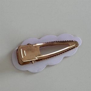 Detail view of the golden metal alligator clip structure and non-slip teeth grip design