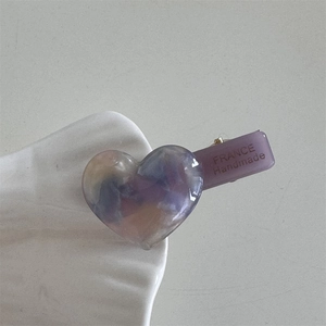Macro shot of purple heart acetate hair clip with FRANCE Handmade text engraving