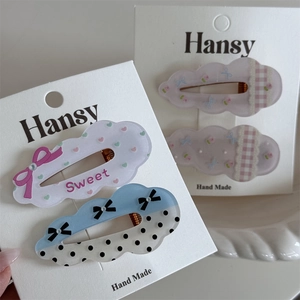 Detail view of cute polka dot cloud hair clips in sweet pastel colors on card