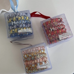 Floral print spiral hair ties in transparent gift boxes with decorative ribbons