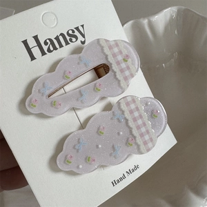 Detail shot of cloud-shaped glitter hair clips with floral bow and plaid lace accents