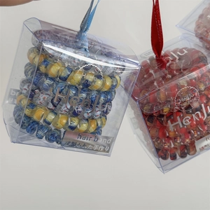 Floral print spiral hair bands in clear gift box with blue star patterns and ribbons