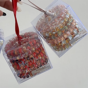 Two boxes of floral spiral hair ties in transparent cases with elegant silk ribbons