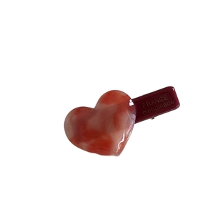 Handmade heart-shaped acetate hair clip in tortoiseshell red for fringe styling