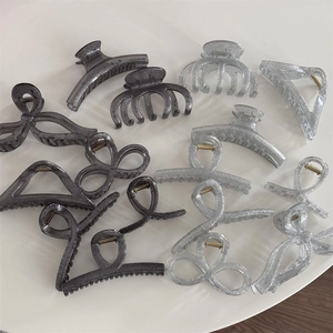 Glittery black and silver hair claw clips set in various shapes for women's hair styling