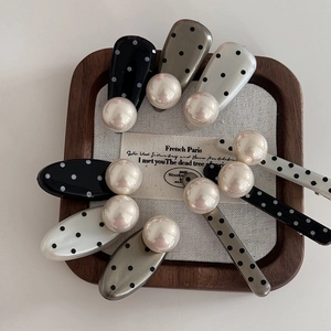 Polka dot hair clip set with white pearls on elegant wooden tray background