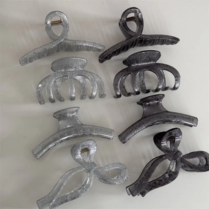 Detail view of glitter shark hair claws in silver and black colors with four various shapes