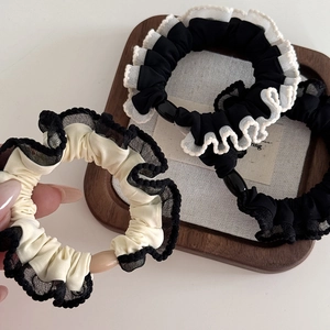 Elegant ruffled lace scrunchie with decorative bead and wavy edge design in beige and black