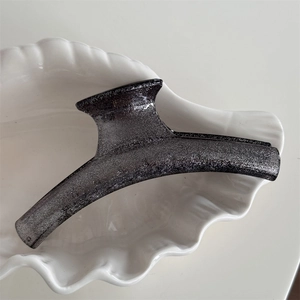 Detailed macro view of the translucent grey shark hair clip with sparkling silver glitter