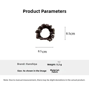 Detail of 8.5cm brown houndstooth scrunchie with lace edge and decorative buckle